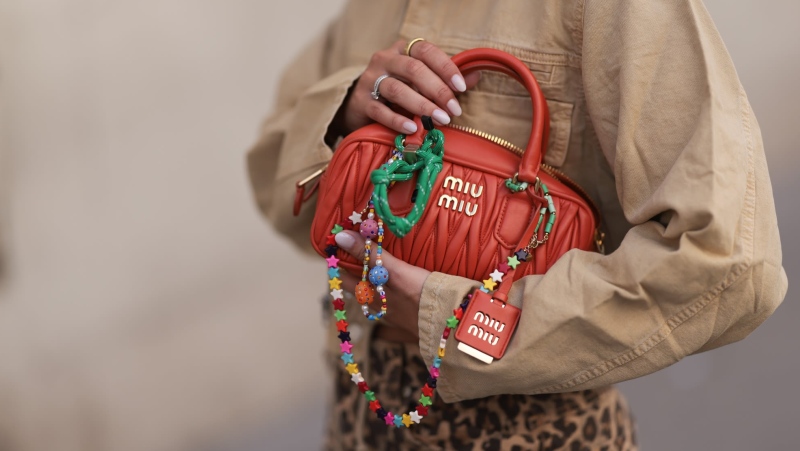 An orange Miu Miu Arcadie bag decked out in charms. (Jeremy Moeller/Getty Images via CNN Newsource)