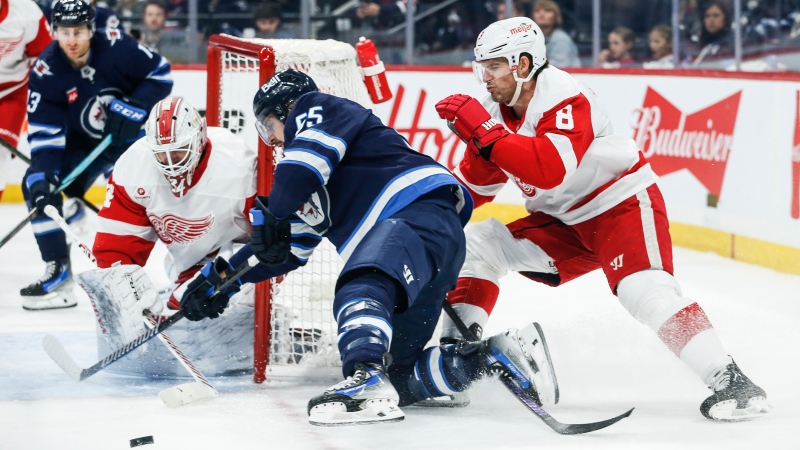 Winnipeg Jets' Mark Scheifele (55) attempts a wraparound on Detroit Red Wings goaltender Alex Lyon (34) as Ben Chiarot (8) defends during second period NHL action in Winnipeg, Jan. 4, 2025. (John Woods/The Canadian Press)