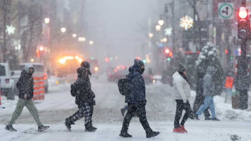 People walk in downtown Montreal, Tuesday, Jan. 9, 2024. Environment Canada has issued a winter storm warning for the province and the city of Montreal is expected to see close to 15cm of snow, ice pellets and freezing rain by morning. (Christinne Muschi / The Canadian Press)