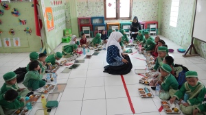 Students sit on the floor as they have their meals during the kick off of President Prabowo Subianto's ambitious free meal program to feed children and pregnant women nationwide despite critics saying that its required logistics could hurt Indonesia's state finances and economy at Early Childhood Education and Development in Jakarta, Indonesia, Monday, Jan. 6, 2025. (AP Photo/Achmad Ibrahim)