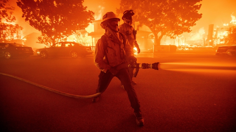 Firefighters battle the Palisades Fire as it burns multiple structures in the Pacific Palisades neighborhood of Los Angeles, Tuesday, Jan. 7, 2025. (Ethan Swope / The Associated Press)