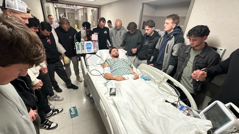 Soccer player Nathan Demien is surrounded by his teammates in this photo taken in hospital. 