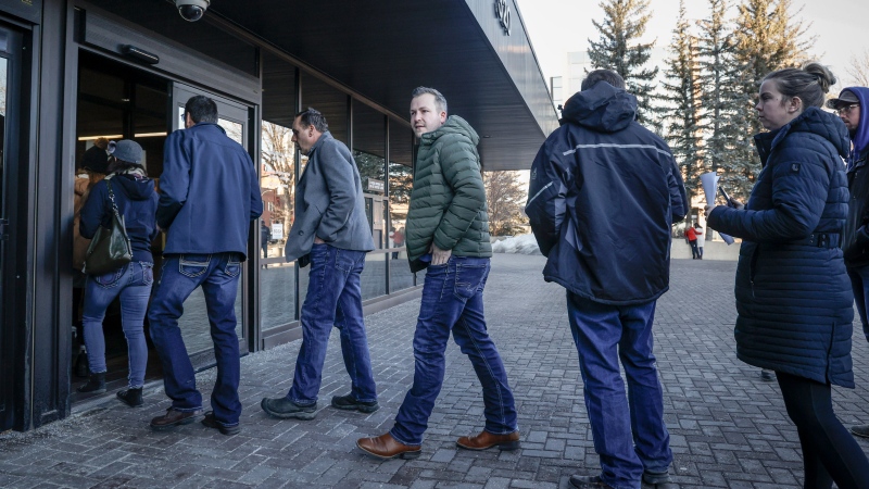 Marco Van Huigenbos, centre, waits in line as he arrives at court for a sentencing hearing in Lethbridge, Thursday, Jan. 9, 2025. Two men who became the faces of a COVID-19 protest blockade at a key border crossing between Alberta and the United States nearly three years ago will learn their fates Friday. THE CANADIAN PRESS/Jeff McIntosh