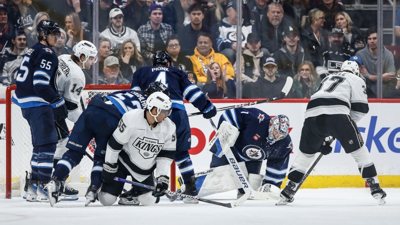 Winnipeg Jets goaltender Eric Comrie (1) jumps on the Los Angeles Kings rebound during second period NHL action in Winnipeg on Friday, January 10, 2025. THE CANADIAN PRESS/John Woods