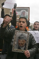 A Palestinian holds a poster of the late Palestinian leader Yasser Arafat during a rally calling for an end to the internal fighting, in the West Bank city of Hebron, Saturday Feb. 3, 2007. (AP / Nasser Shiyoukhi)