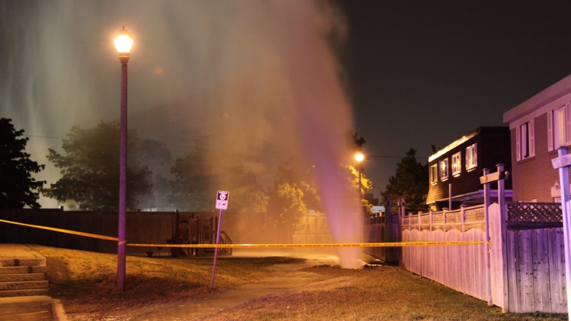 A stream of water shoots from a broken watermain on townhouse crescent in Brampton on Saturday, July 14 2012. (Tom Podolec / CTV Toronto)