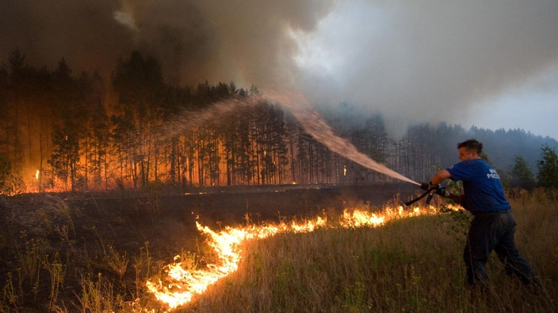 A fire fighter attempts to extinguish a forest fire near the village of Dolginino in the Ryazan region, some 180 km southeast of Moscow, Wednesday, Aug. 4, 2010. (AP Photo)