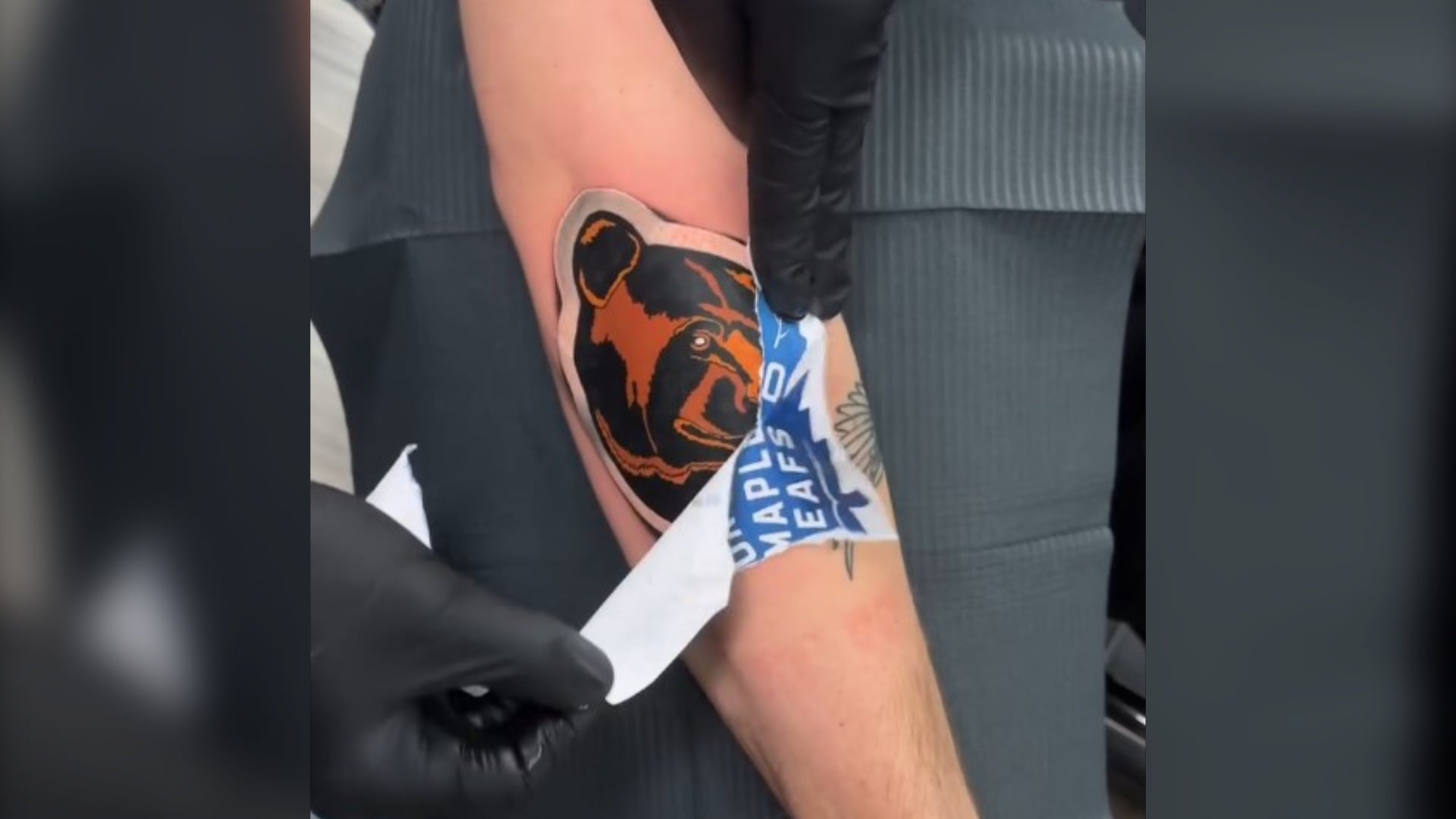 Luke Cormier peels off a Toronto Maple Leafs sticker, to reveal a Boston Bruins tattoo underneath. (Courtesy: Luke Cormier)